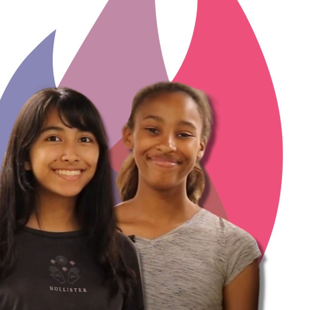 Two young women in front of flame logo of St. John the Evangelist Columbia MD